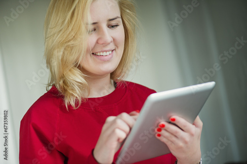 Woman smiling and looking at ipad - tablet