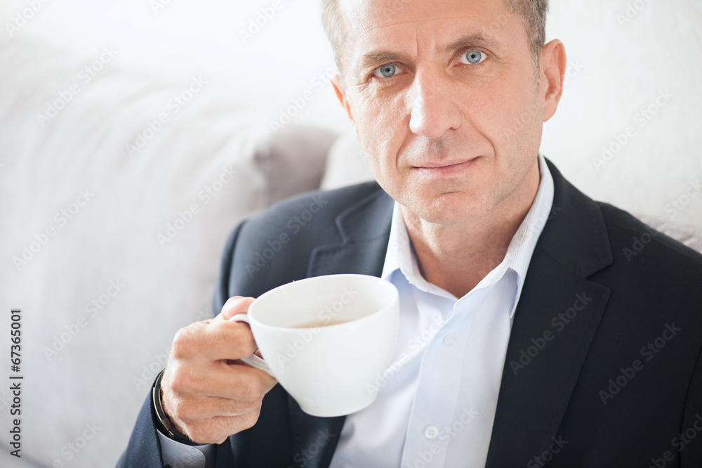Mid age man drinking coffee at home Mid age man drinking coffee at home