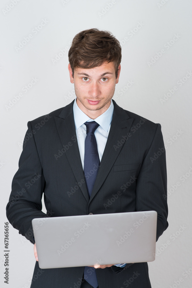 handsome businessman holding a laptop handsome businessman holding a laptop