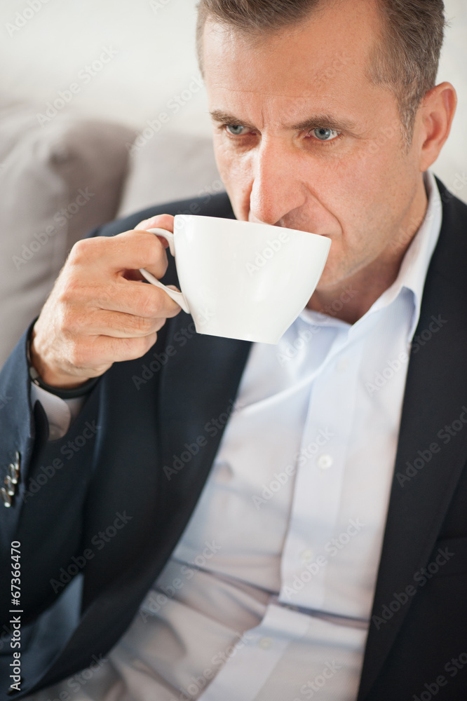 Close portrait of handsome businessman drinking a cup of coffee Close portrait of handsome businessman drinking a cup of coffee