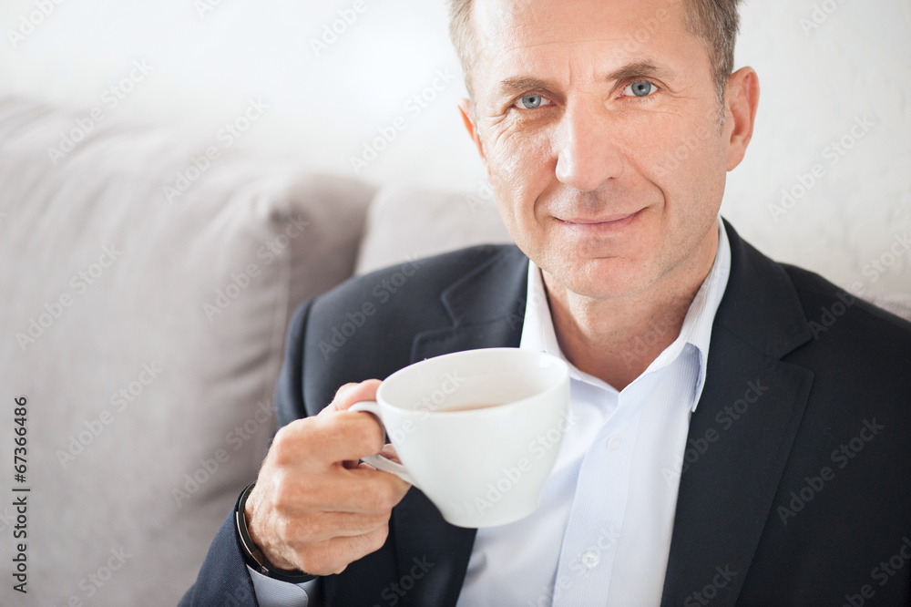 Mid age man drinking coffee at home Mid age man drinking coffee at home