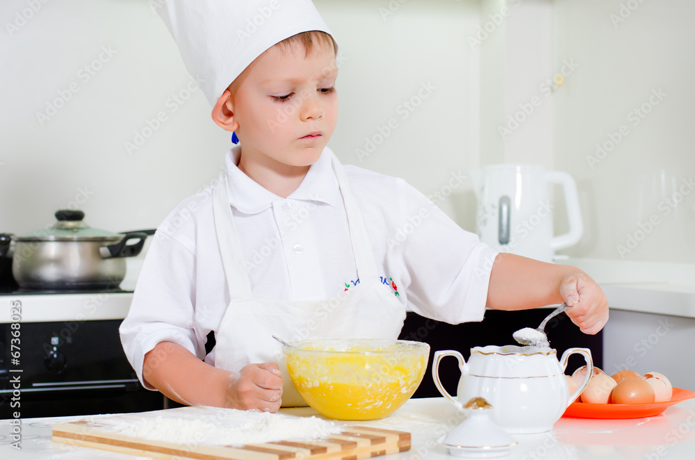 Young boy chef adding ingredients to his bowl Young boy chef adding ingredients to his bowl
