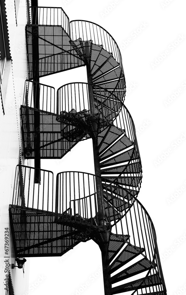 Naklejka premium Kręte metalowe spiralne schody, czarno-biały obraz.