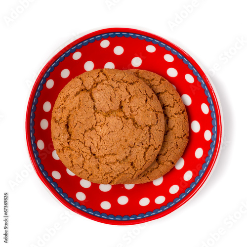 Ginger cookies on red white dotted dish isolated on white backgr photo