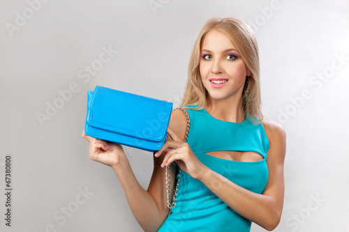 Красивая блондинка с синей маленькой сумочкой