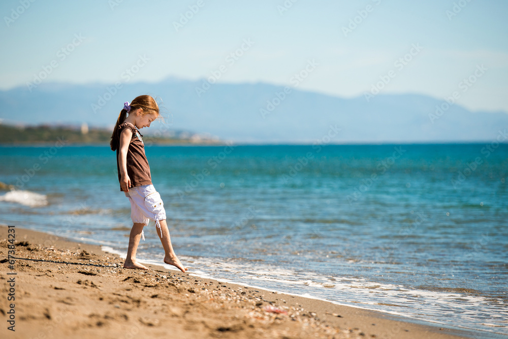 little girl walks on the  beach