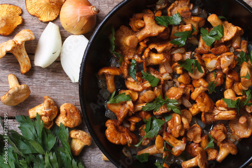 chanterelle mushrooms with onion and parsley  in a pan top view photo
