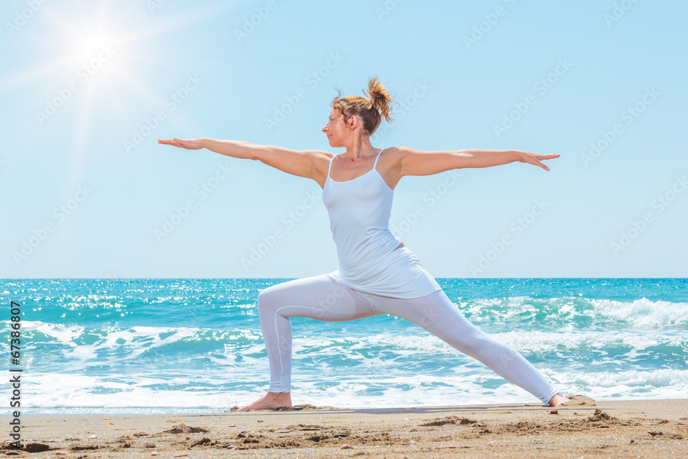 woman practicing yoga at seashore