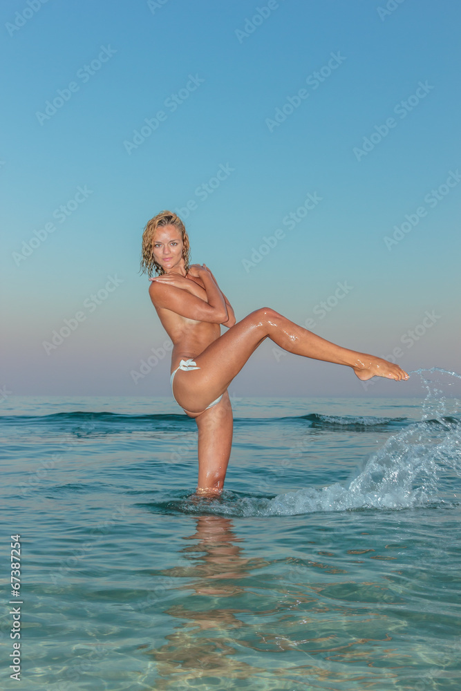 Sexy young woman topless posing on the beach Sexy young woman topless posing on the beach
