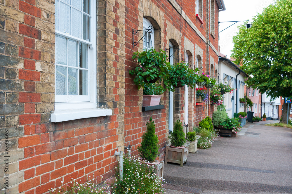 Row of hanging baskets outside red brick houses