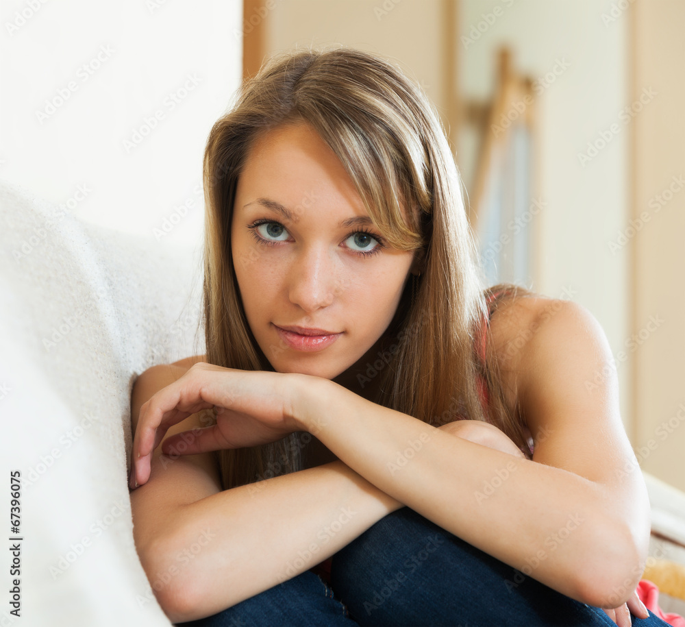 Fototapeta premium Sad girl sitting on couch