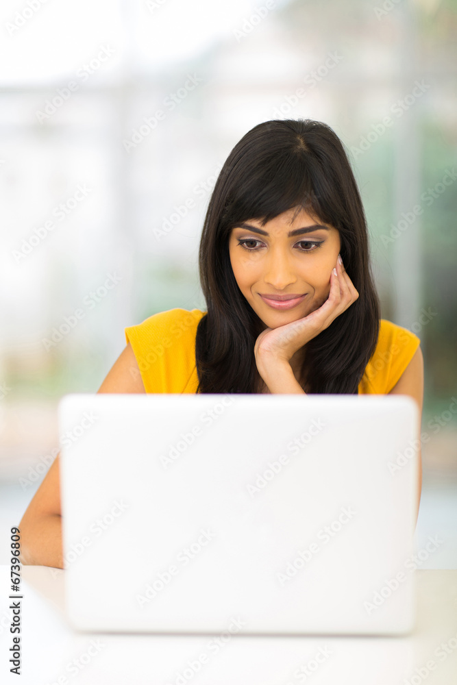 indian woman looking at computer screen