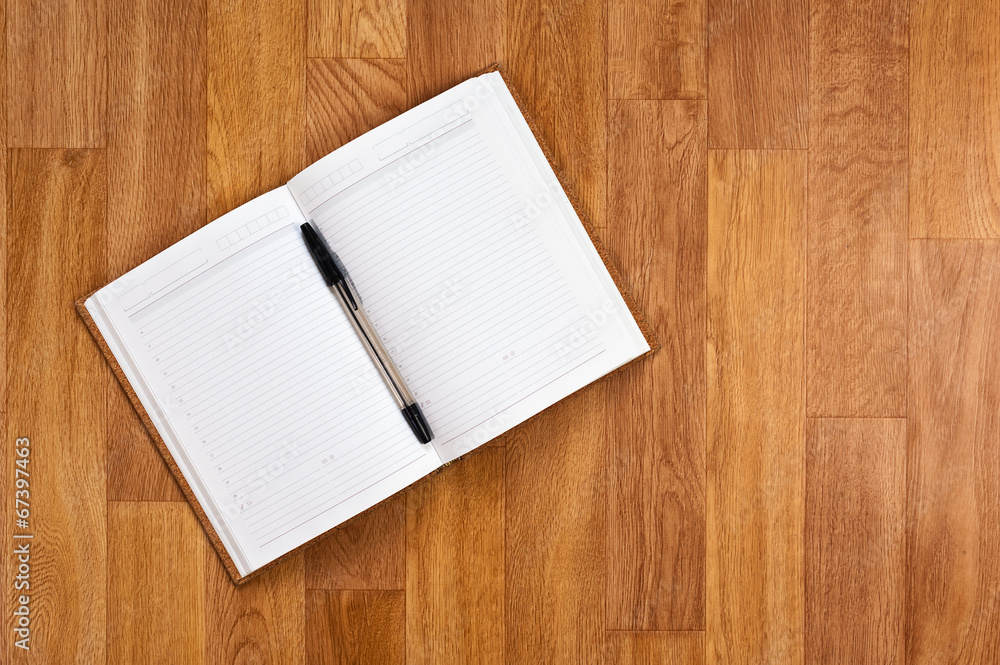 Blank notepad with office supplies on wooden table.