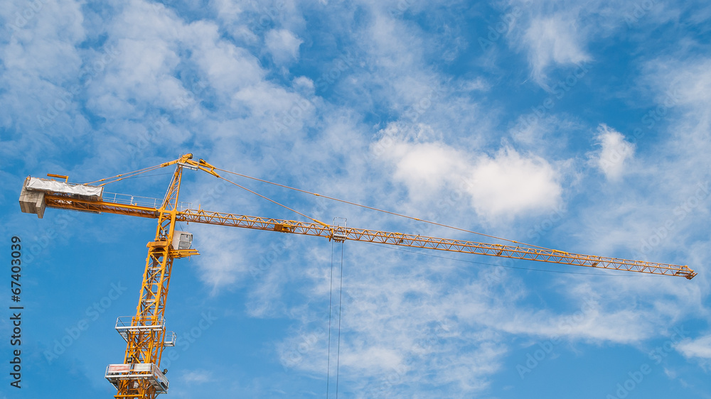 Yellow construction tower crane with blue sky Yellow construction tower crane with blue sky
