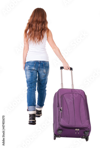 back view of walking woman with suitcase