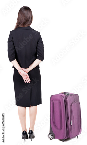 back view of thoughtful business woman traveling with suitcas.