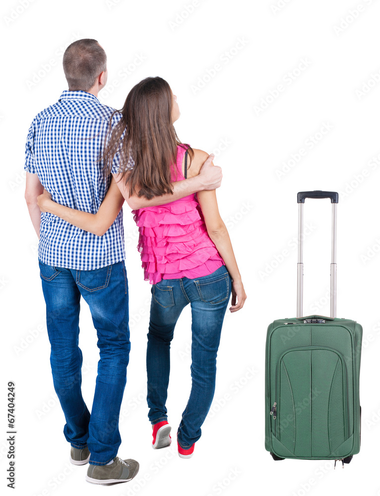 Back view of young couple traveling with suitcas . Back view of young couple traveling with suitcas .