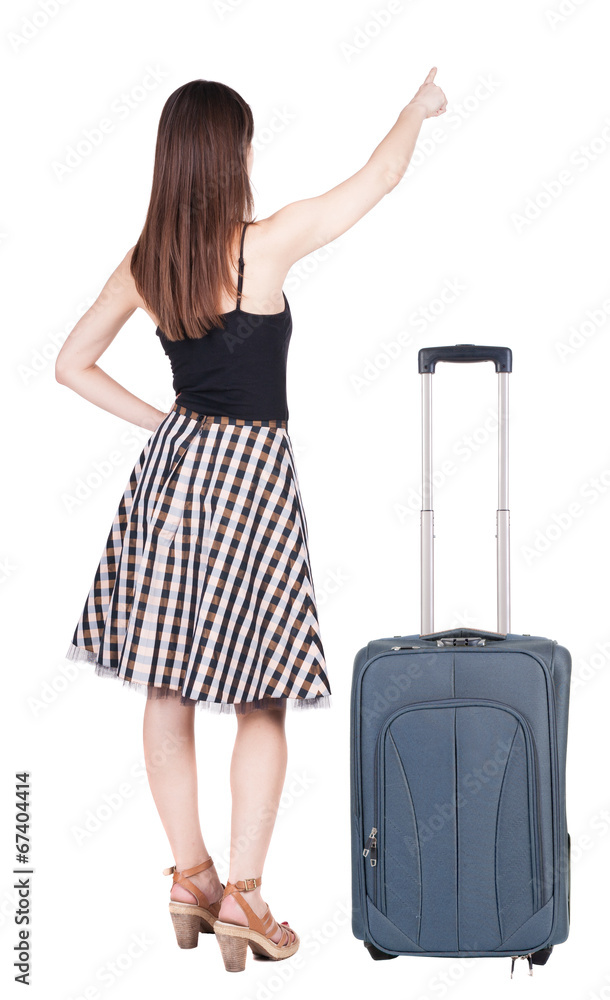 Back view of young brunette woman traveling with suitcas and poi Back view of young brunette woman traveling with suitcas and poi