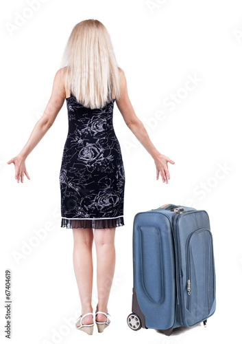 Back view of shocked woman traveling with suitcas .