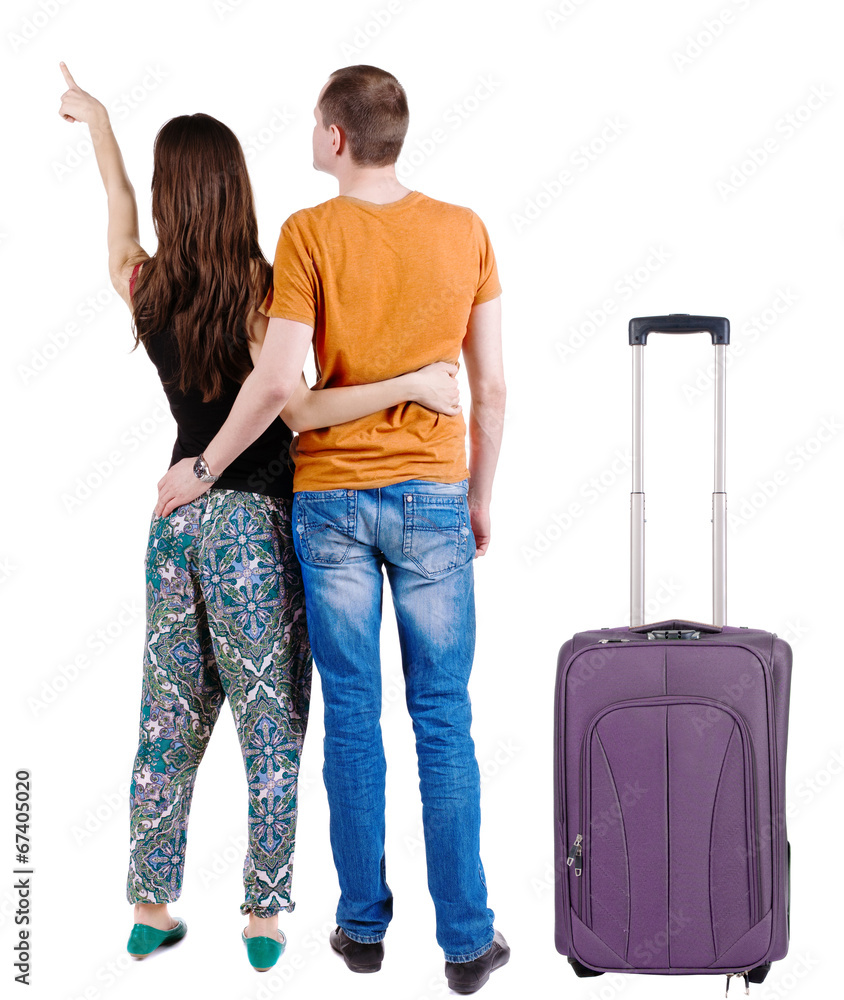 young couple traveling with suitcas and pointing at wal Back vie young couple traveling with suitcas and pointing at wal Back vie