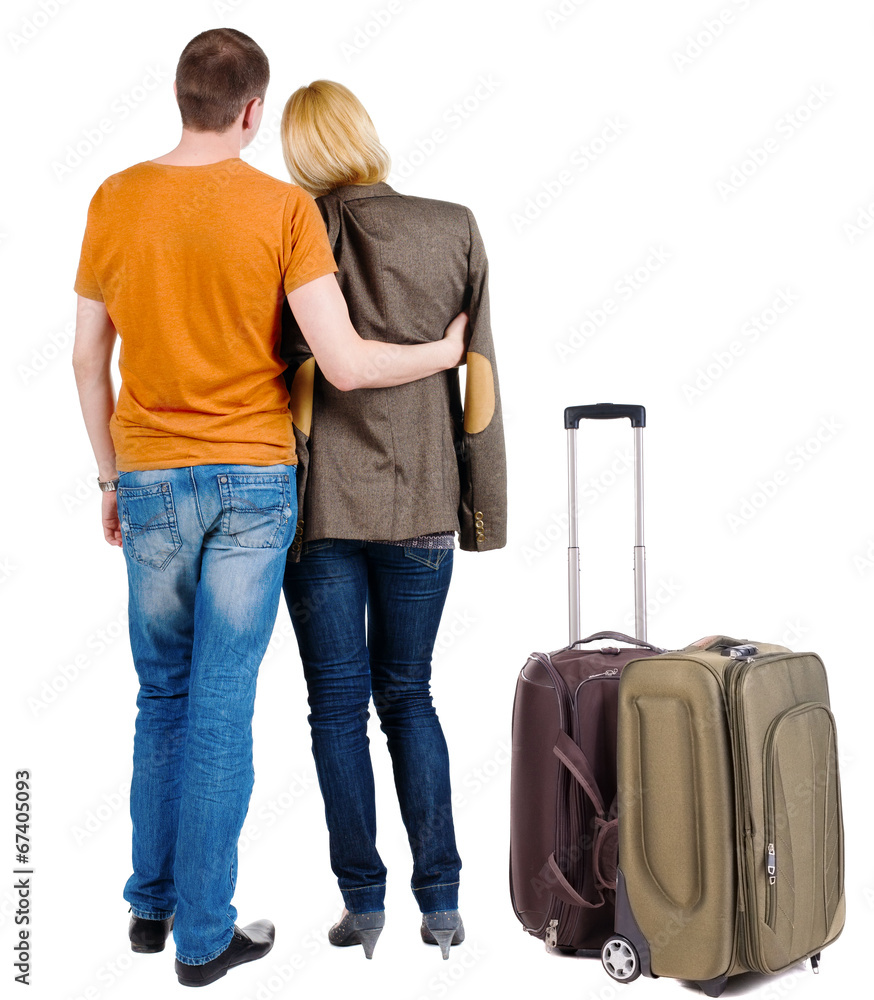 Back view of young couple traveling with suitcas . Back view of young couple traveling with suitcas .