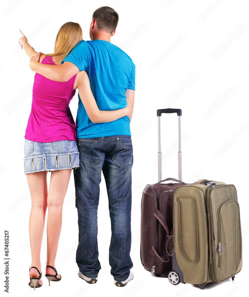 Back view of young couple traveling with suitcas . Back view of young couple traveling with suitcas .