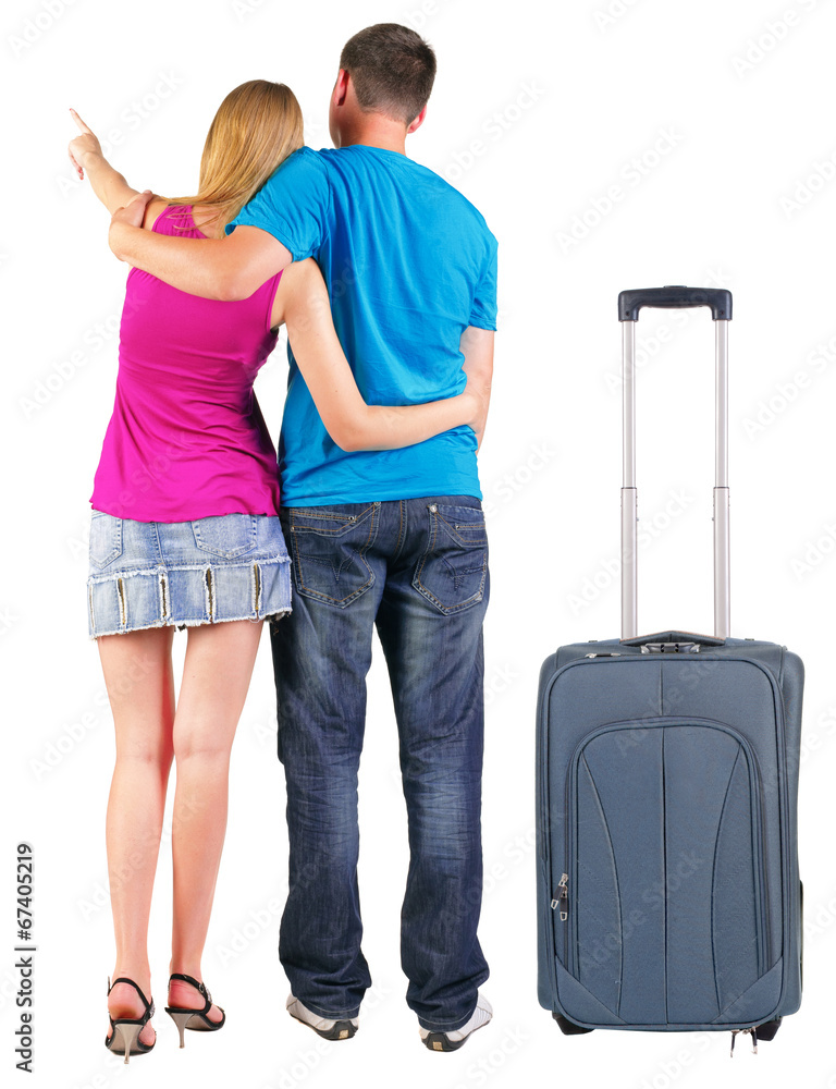 Back view of young couple traveling with suitcas . Back view of young couple traveling with suitcas .