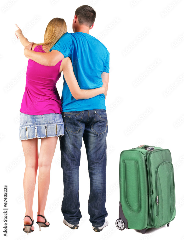 Back view of young couple traveling with suitcas . Back view of young couple traveling with suitcas .