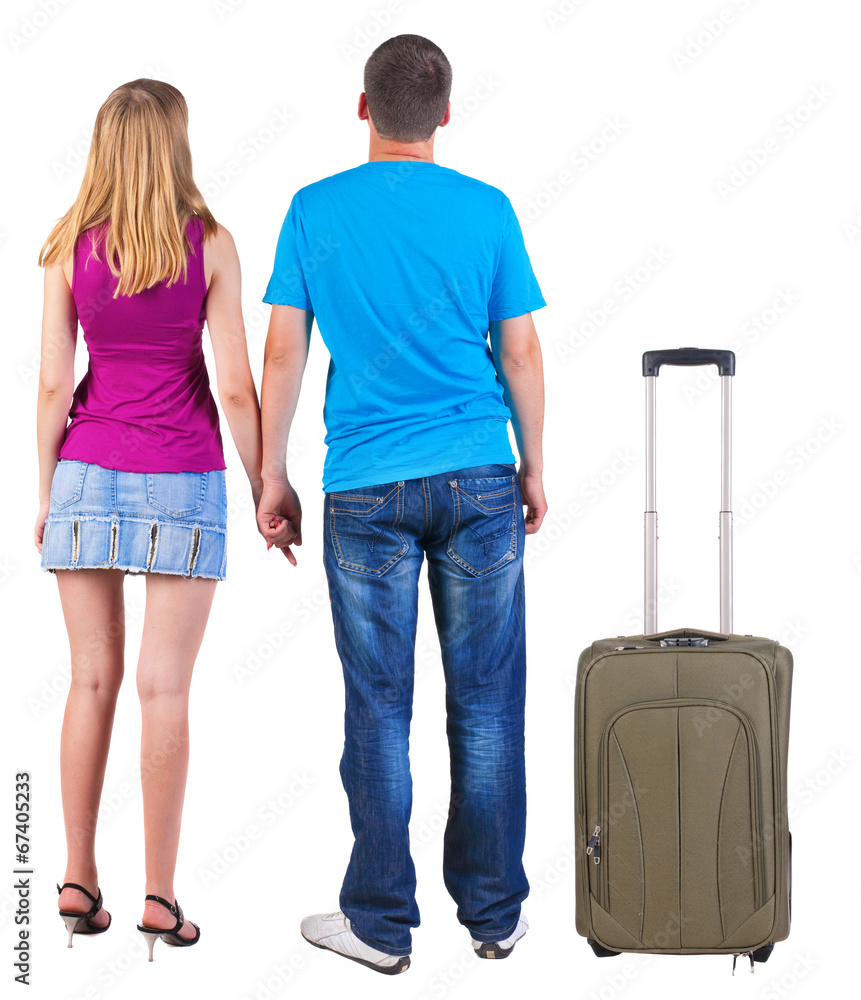 Back view of young couple traveling with suitcas . Back view of young couple traveling with suitcas .