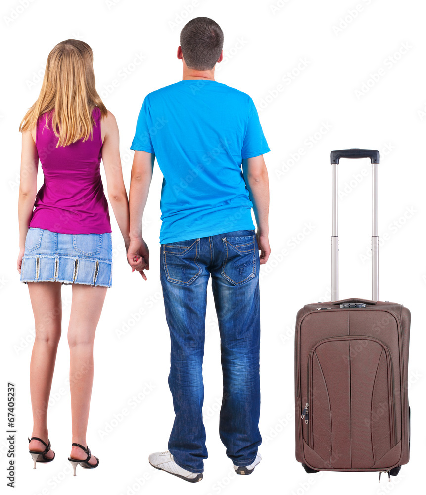 Back view of young couple traveling with suitcas . Back view of young couple traveling with suitcas .