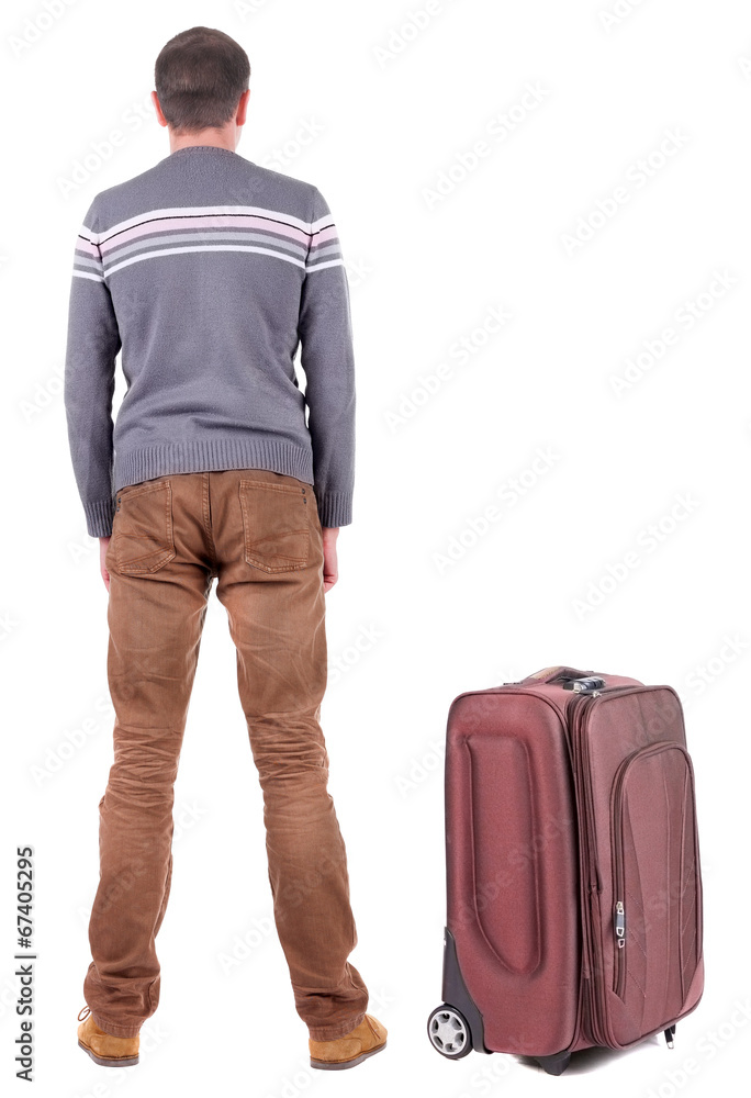 Back view of young man traveling with suitcas. Back view of young man traveling with suitcas.