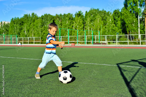 Boy playing football on football pitch
