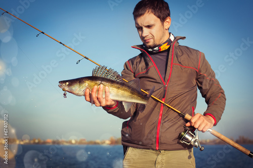 Happy angler with zander fishing trophy