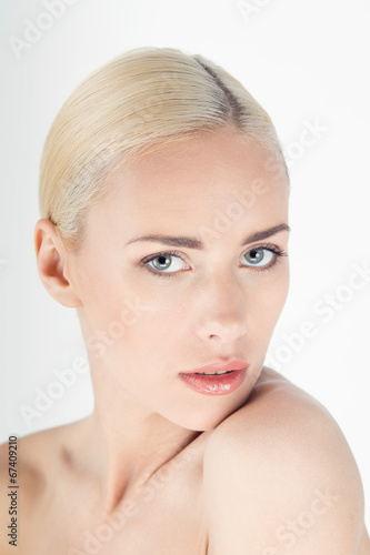 Closeup portrait of beautiful young blonde woman on white backgr