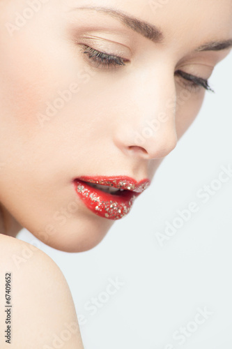 Lips of young blonde woman with vogue shining sparkle