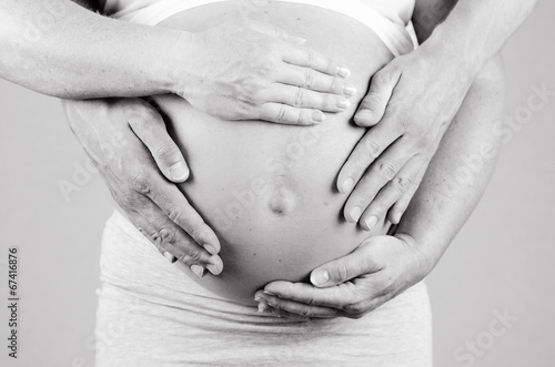 parents hands on the belly of the mother