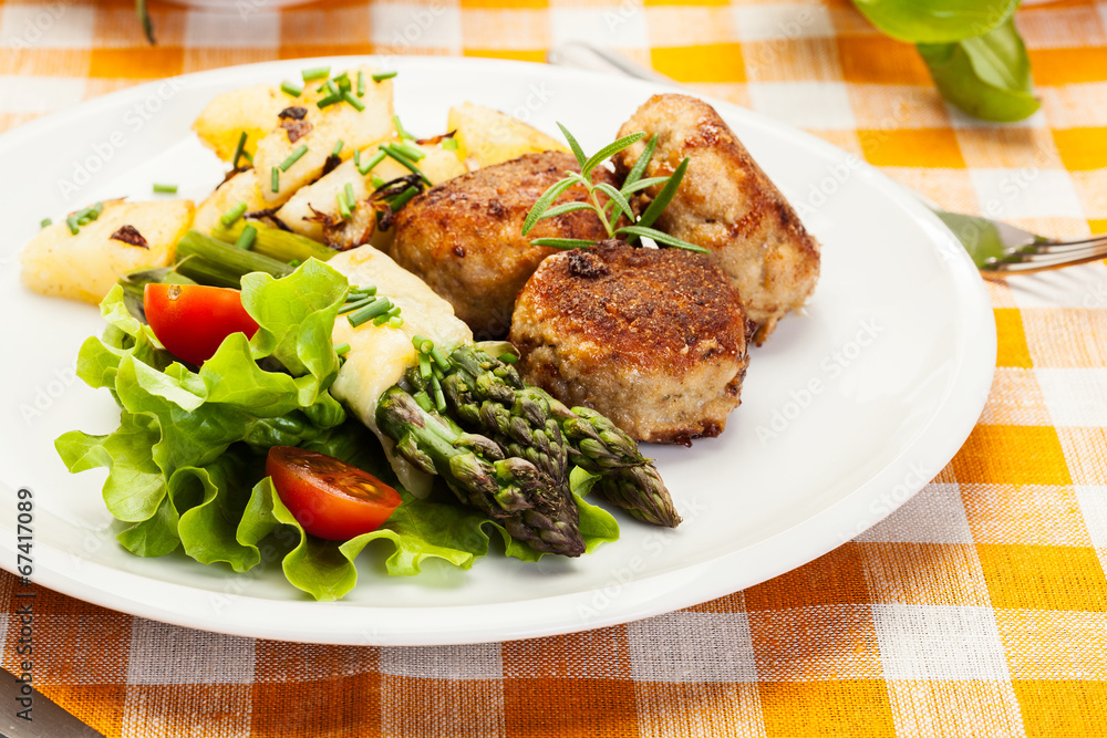 Meatballs served with boiled potatoes and asparagus Meatballs served with boiled potatoes and asparagus