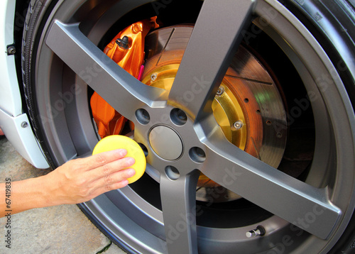 Hand with a sponge wipe the car polishing