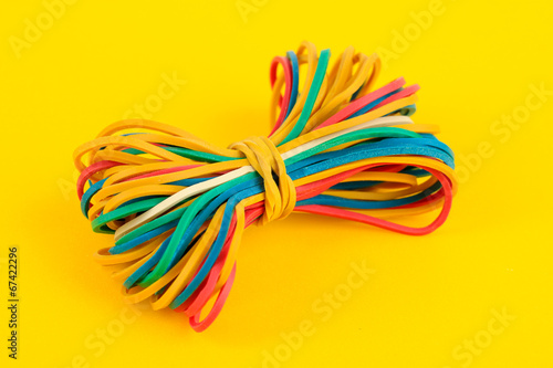 Colorful rubber bands on yellow background
