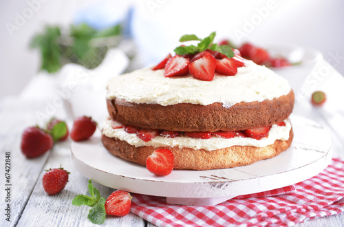 Delicious biscuit cake with strawberries on table close-up