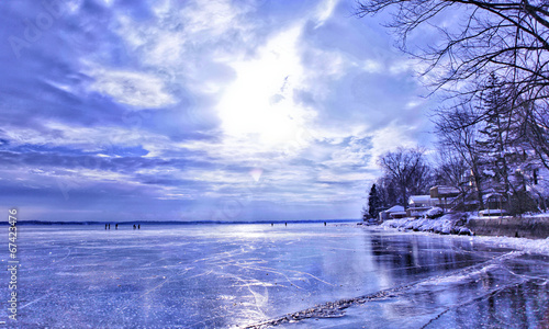 Frozen Lake - reflective ice, shoreline, dramatic sky