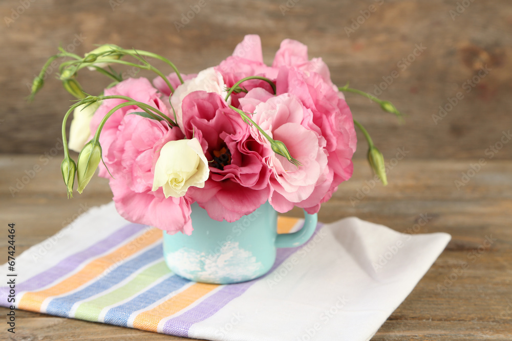 Bouquet of eustoma flowers in vase on wooden background Bouquet of eustoma flowers in vase on wooden background