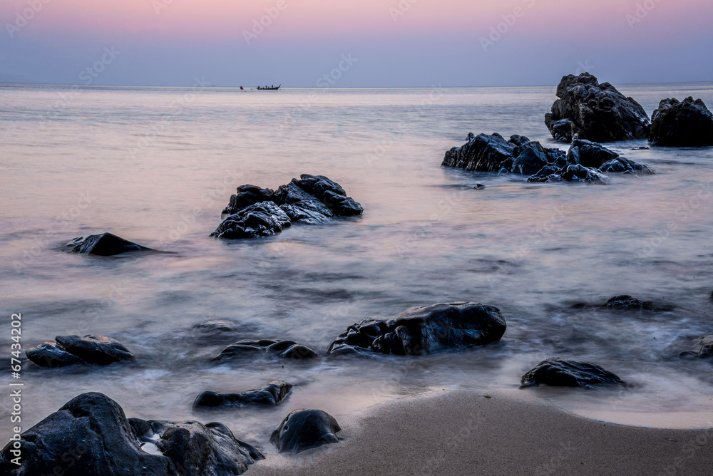 Obraz premium Pink sky over a rocky seashore. Sunset landscape. Thai Boat. Tro