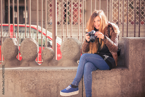 Young beautiful photographer girl, taking photos in a beautiful
