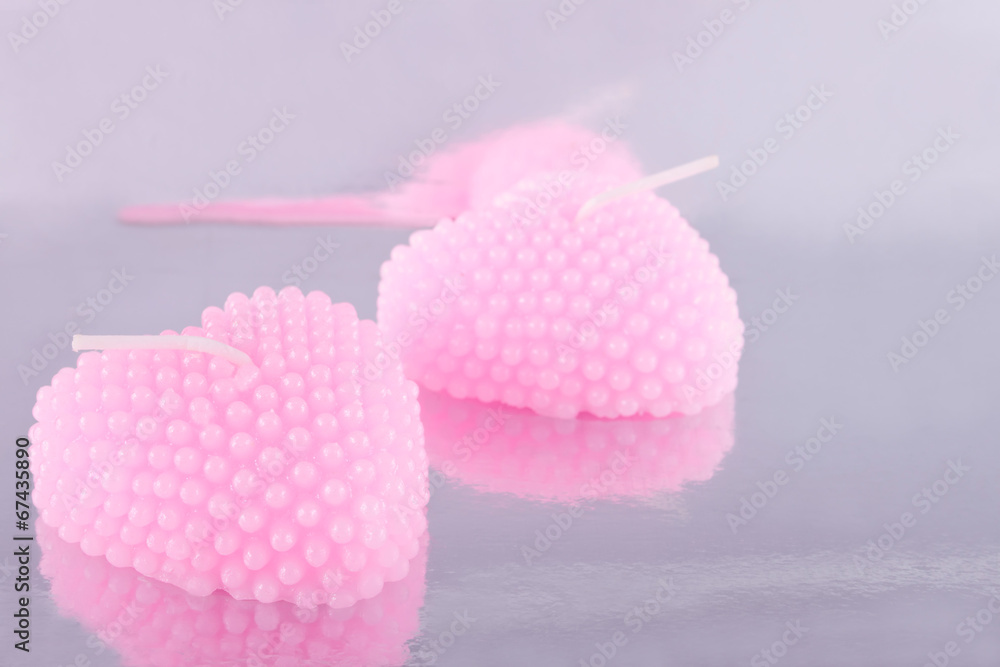 The couple of pink candles in the shape of heart The couple of pink candles in the shape of heart