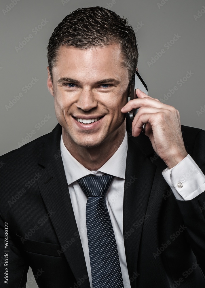 Well-dressed man in black suit with mobile phone Well-dressed man in black suit with mobile phone