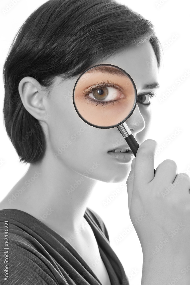 young woman looking through magnifying glass young woman looking through magnifying glass