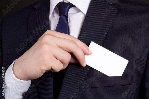 close up of businessman holding visiting card out of his suit po