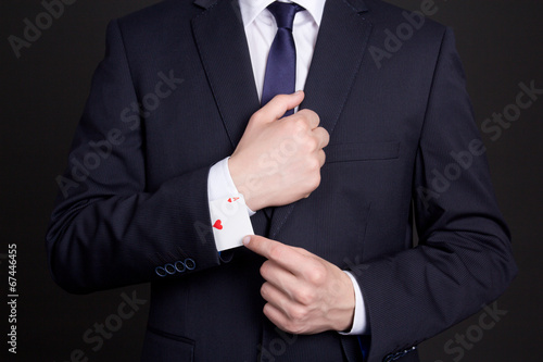businessman with ace card hidden under sleeve photo