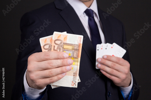 money and four aces cards in mans hands